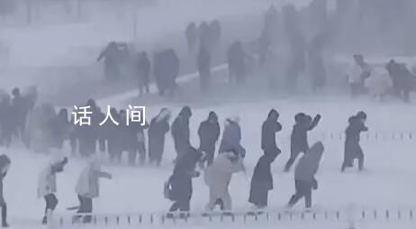 哈爾濱學(xué)生在暴風(fēng)雪中艱難行走 街道路面猶如溜冰場