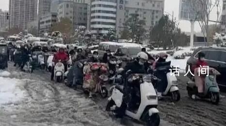 河南市民騎電動車在雪地里艱難前行 走路上班的步履艱難