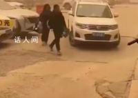 女子出行遇新疆14級大風 路邊有車輛車門被吹壞